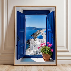 Könnte beinhalten: Ein rechteckiger Wandkunstdruck, der ein offenes Fenster mit leuchtend blauen Fensterläden zeigt. Der Blick durch das Fenster offenbart weiße Gebäude mit blauen Kuppeln über einem tiefblauen Meer. Ein Terrakottatopf mit rosa Blumen steht auf dem Sims.