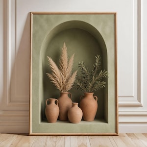 May include: A framed wall art print featuring a sage green arched alcove containing four terracotta-coloured clay vases. Two vases hold dried pampas grass plumes and green olive branches. The frame is light wood, and the art has a textured finish.