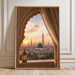May include: A framed wall art print featuring a view through an ornate stone archway with a beige curtain. The scene depicts the Prophet's Mosque in Medina at sunset, with its iconic green dome, tall minarets, palm trees, and a lit gold lantern.