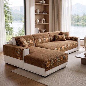 May include: A white sectional sofa covered with brown fabric slipcovers featuring a repeating geometric star pattern in shades of blue, orange, and cream. The set includes matching rectangular throw pillows placed on the seat cushions.