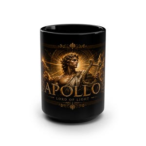 May include: A black ceramic mug featuring a gold-toned illustration of Apollo holding a lyre. The text APOLLO LORD OF LIGHT is printed in gold lettering across the centre. The design includes radiant sunburst patterns and decorative borders.