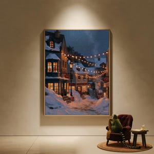 May include: A rectangular wall art print depicting a snowy village street at night. The scene features multi-story buildings with glowing windows, a dark blue sky, and warm string lights draped across the street above a snow-covered path.