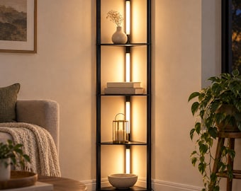 May include: A tall, black corner shelf unit featuring four triangular tiers and integrated vertical LED lighting strips along the back frame. The shelves hold a white vase with dried flowers, stacked books, a gold lantern, and a bowl.