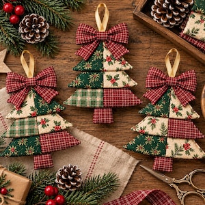 May include: Three fabric Christmas tree ornaments featuring patchwork designs in red, green, and cream with holly and plaid patterns. Each tree is topped with a matching fabric bow and a gold ribbon loop for hanging, arranged on a wooden surface.