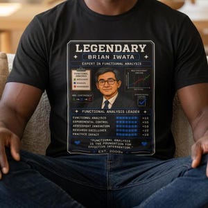 May include: A black t-shirt featuring a graphic print of a man in a suit with glasses, surrounded by charts, text reading LEGENDARY BRIAN IWATA EXPERT IN FUNCTIONAL ANALYSIS, and a list of skills with blue progress bars and the text EST. 2000.