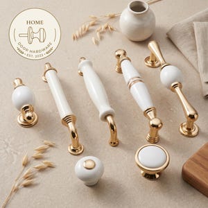 Puede incluir: Una colección de herrajes para muebles con acabados en cerámica blanca y metal dorado pulido. El conjunto incluye varios tiradores de cajón, manijas y pomos. Un logotipo circular en la esquina superior izquierda muestra el texto HOME DOOR HARDWARE EST. 2023.