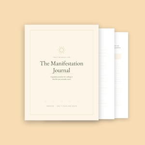 Peut inclure: Un journal de couleur crème intitulé The Manifestation Journal avec une icône de soleil, portant le texte Truly Blissful Life et A guided practice for calling in the life you actually want, avec des pages lignées intérieures visibles derrière.