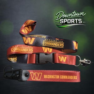 May include: A Washington Commanders lanyard and matching keychain in burgundy and gold. The lanyard features a black plastic buckle, a metal clip, and the team name and logo. The keychain includes a black metal ring and a fabric strap with the team name.