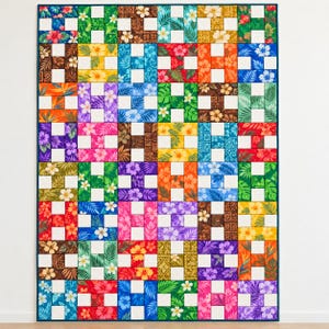 May include: A rectangular quilt featuring a grid of H-shaped blocks made from various cotton fabrics. Each block displays vibrant tropical floral and leaf patterns in colors including red, orange, yellow, green, blue, purple, and brown.