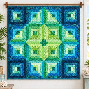 May include: A square fabric quilt featuring a log cabin pattern in shades of navy blue, turquoise, teal, and lime green. The design consists of concentric rectangular fabric strips arranged in a geometric layout, suspended from a wooden rod.