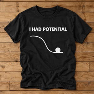 Könnte beinhalten: Ein schwarzes T-Shirt mit kurzen Ärmeln und dem weißen Schriftzug I HAD POTENTIAL über einer Grafik, die eine geschwungene Linie als Hang darstellt, an dessen unterem Ende ein kleiner weißer Kreis liegt, was potenzielle Energie veranschaulicht.