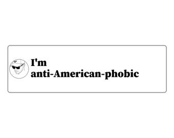 May include: A rectangular white sticker featuring a circular black and white line drawing of a person wearing a baseball cap and sunglasses on the left side, followed by the black text I'm anti-American-phobic printed in a bold serif font.