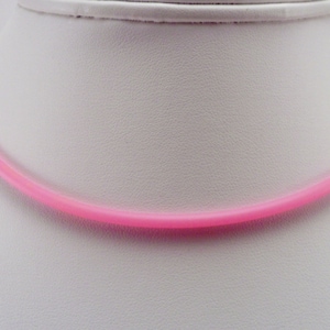 May include: A pink rubber necklace. The necklace is simple and plain, with no embellishments.