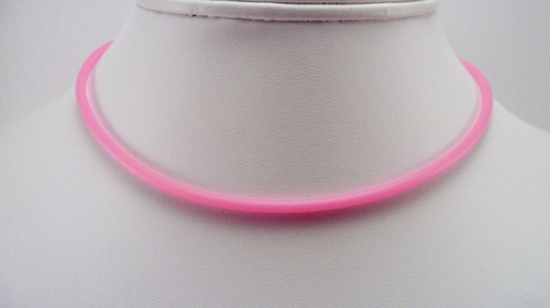 May include: A pink rubber necklace. The necklace is simple and plain, with no embellishments.