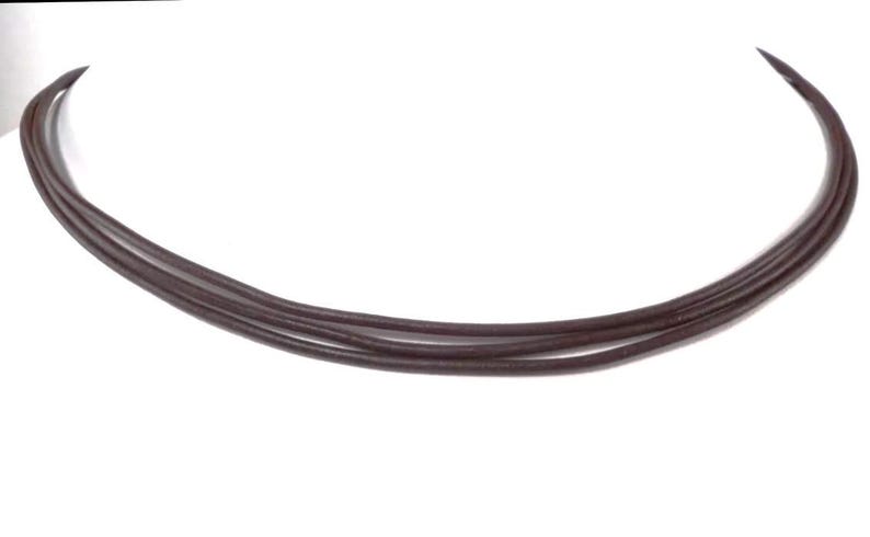 May include: A brown leather choker necklace with multiple strands.