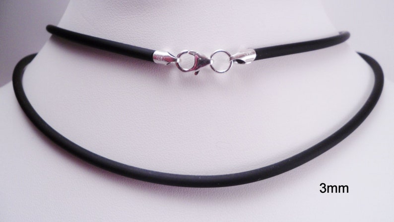 May include: A black rubber necklace with a silver clasp. The necklace is 3mm thick.
