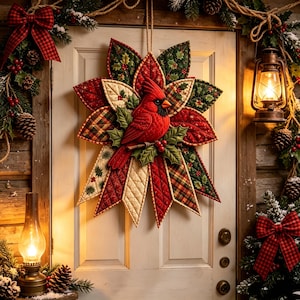 May include: A quilted fabric wall hanging shaped like a star, featuring a central red cardinal bird perched on a branch with green holly leaves and red berries. The star points consist of various red, green, and cream fabrics with plaid and floral patterns.