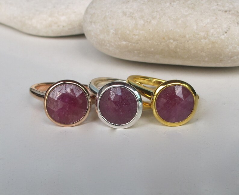 Pu&ograve; includere: Tre anelli con una pietra preziosa rosa incastonata in una montatura a becco di lumaca. Gli anelli sono in oro, argento e oro rosa.