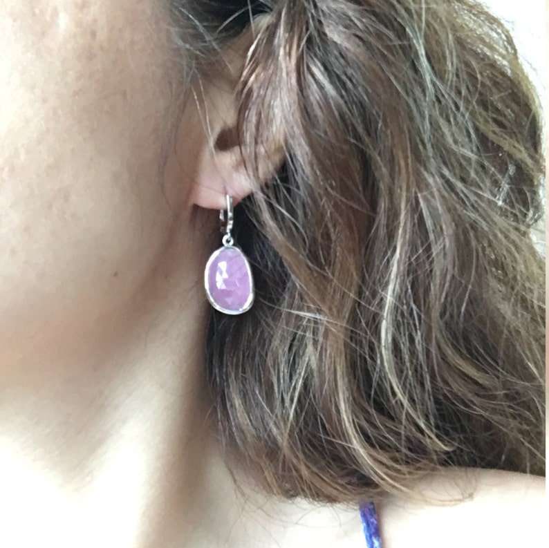 K&ouml;nnte beinhalten: Ein Paar silberne Ohrh&auml;nger mit einem rosafarbenen ovalen Edelstein. Die Ohrringe haben ein schlichtes Design und sind perfekt f&uuml;r den Alltag.