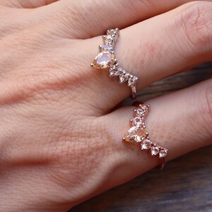 May include: Two gold rings with clear and light brown stones set in a V-shape design.