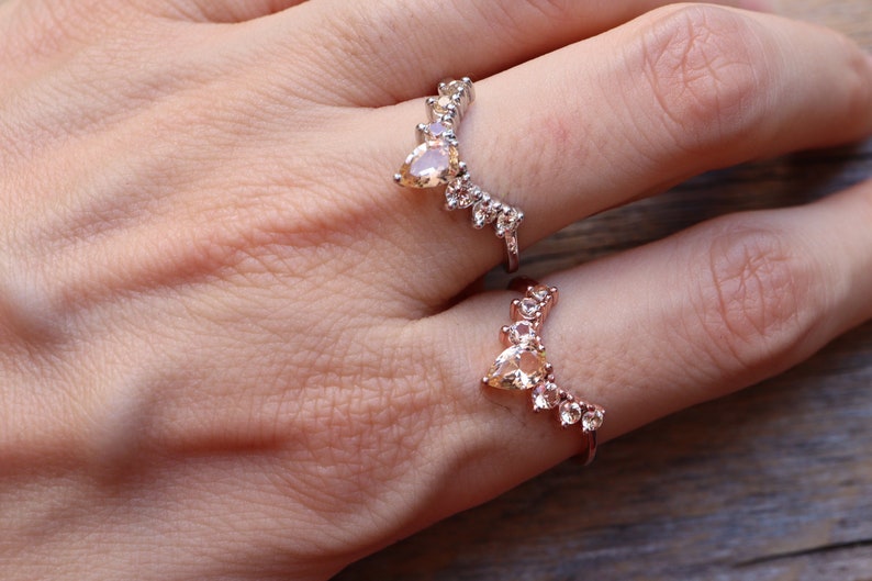 May include: Two gold rings with clear and light brown stones set in a V-shape design.