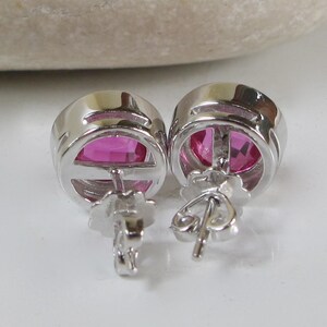 Puede incluir: Un par de pendientes de plata con piedras ovaladas de color rosa.