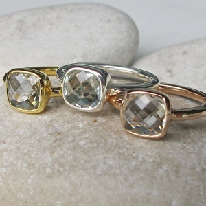 Puede incluir: Tres anillos con piedras preciosas cuadradas transparentes engastadas en bandas de oro, plata y oro rosa.