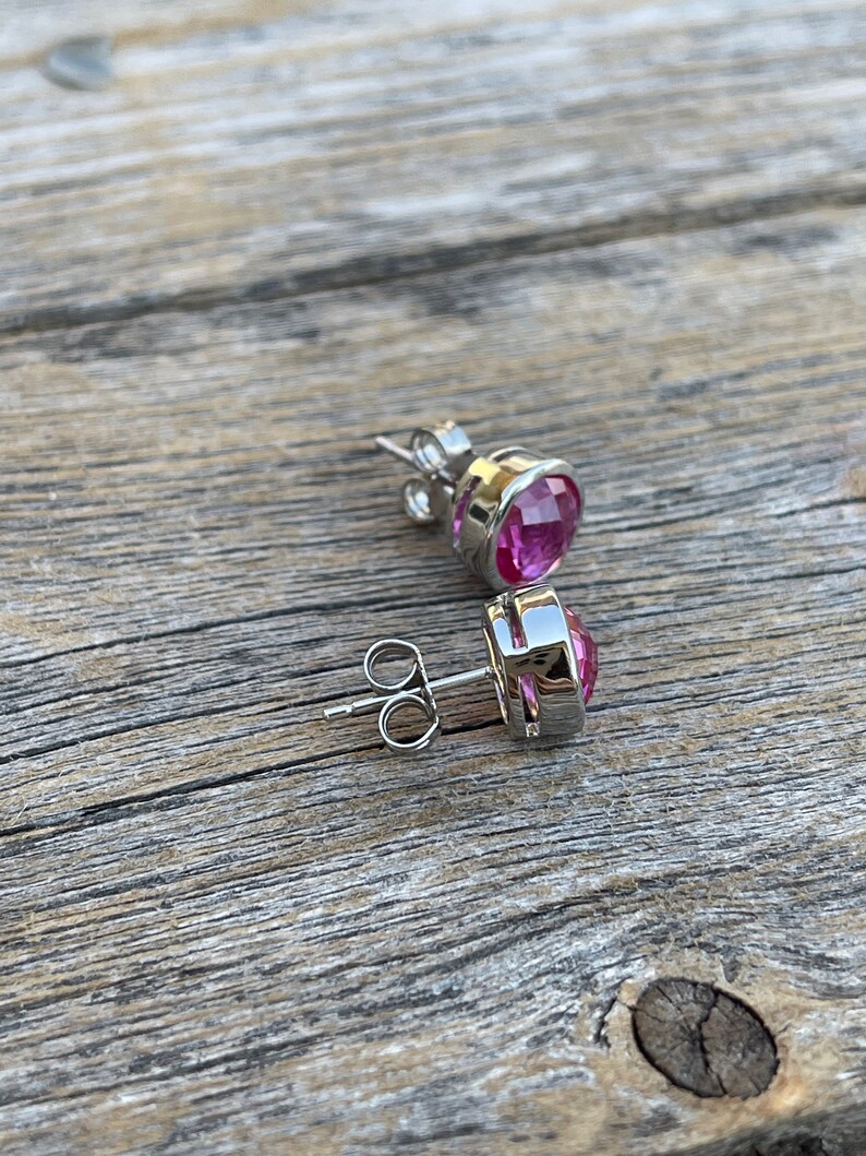 Puede incluir: Un par de pendientes de plata con piedras preciosas rosas. Los pendientes tienen un dise&ntilde;o sencillo y son perfectos para el uso diario.