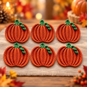 Può includere: Un set di sei sottobicchieri a forma di zucca lavorati all'uncinetto in arancione, ognuno con una consistenza a coste e un piccolo stelo verde all'uncinetto con un dettaglio a viticcio riccio, disposti in due file da tre su un tessuto neutro.