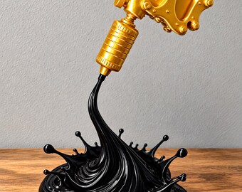 Könnte beinhalten: Eine goldfarbene Tattoo-Maschinen-Skulptur, die über einem schwarzen Sockel schwebt. Die Maschine hat ein metallisches Finish mit sichtbaren Schrauben und einem zylindrischen Griff. Ein schwarzer, flüssigkeitsartiger Strom fließt von der Maschine in eine spritzförmige Basis.