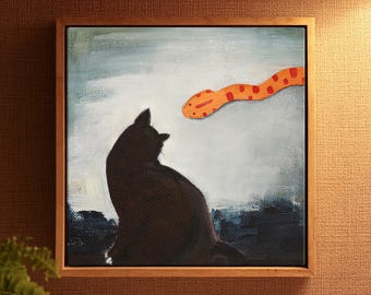 May include: A square framed painting featuring a silhouette of a black cat sitting and looking toward an orange snake with red spots. The background is a textured light blue and white sky above a dark blue ground, all encased in a wooden frame.