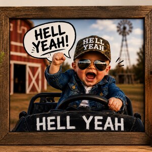 Puede incluir: Una fotografía enmarcada de un niño con una gorra de béisbol de camuflaje con el texto HELL YEAH, gafas de sol y una chaqueta vaquera. El niño está en un vehículo de juguete negro con HELL YEAH impreso. Un globo de texto dice HELL YEAH.