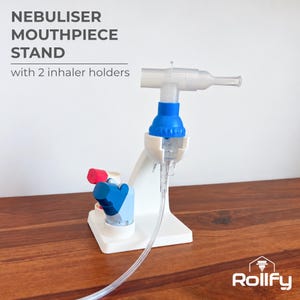 May include: A white nebuliser mouthpiece stand with two inhaler holders. The stand features a central support for a nebuliser cup and mouthpiece assembly, with a clear tube attached. Text reads: NEBULISER MOUTHPIECE STAND with 2 inhaler holders.