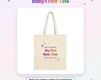 Może przedstawiać: Beżowa torba płócienna z nadrukowanym tekstem Born to sparkle My First New Year 2027 - Mom & Dad wielokolorowymi literami, ozdobiona małymi kolorowymi ikonami gwiazdek. Torba posiada dwa długie paski na ramię i prostokątny kształt.