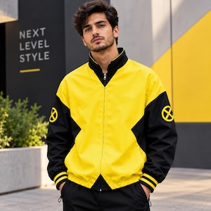 Puede incluir: Una chaqueta con cremallera amarilla y negra que presenta un cuello alto y mangas largas con puños negros. La chaqueta muestra un logotipo circular amarillo de X-Men en cada manga. El diseño incluye un panel central amarillo con paneles laterales negros.