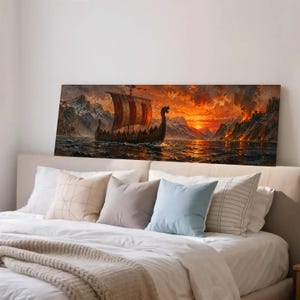 May include: A rectangular wall art print depicting a wooden Viking ship with a red and white striped sail navigating dark water. The background features snow-capped mountains and a fiery orange sunset sky with smoke rising from a distant shore.