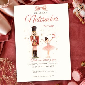 May include: A white birthday invitation card featuring a pink bow, a nutcracker, and a ballerina holding the number 5. Text reads: Join us for a Nutcracker Birthday, Clara is turning five, Saturday, December 12, 2:00 PM, 22 Sugar Plum Lane, RSVP to Mom 555-123-4567, Tutus & twirls encouraged.