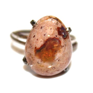 Könnte beinhalten: Ein silberner Ring mit einem tropfenförmigen Opal-Edelstein. Der Opal ist eine Mischung aus Weiß, Braun und Orange mit schillernden Farbeffekten.