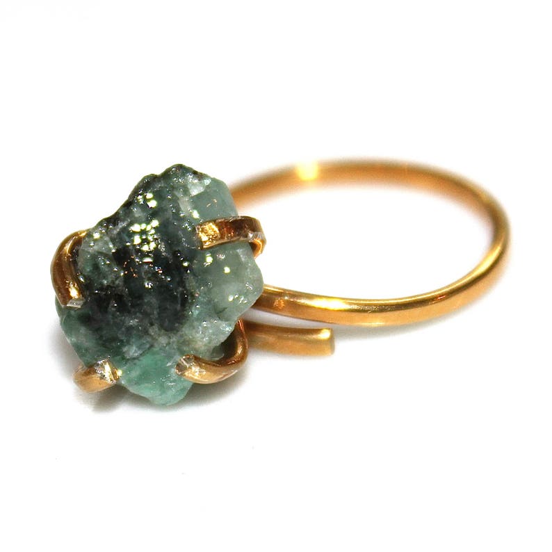 Pu&ograve; includere: Un anello d'oro con un grande smeraldo grezzo. Lo smeraldo &egrave; di colore verde scuro con inclusiones nere.