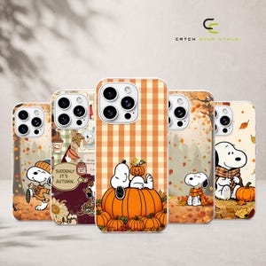 May include: Five smartphone cases featuring Snoopy in autumn-themed designs. The cases display orange and brown color palettes with pumpkins, falling leaves, and plaid patterns. One case includes the text 'SUDDENLY IT'S AUTUMN' and a coffee cup.