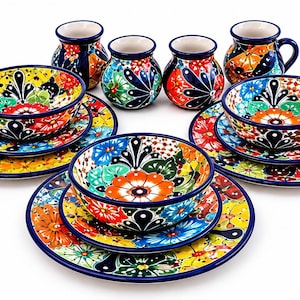 May include: A ceramic dinnerware set featuring three large plates, three matching bowls, and four small pitchers. Each piece is decorated with a vibrant, multi-colored floral pattern in shades of orange, yellow, blue, green, and red, finished with a dark blue rim.