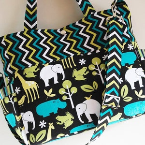 May include: A black and white chevron patterned tote bag with a black and white animal print lining. The bag has a zippered pocket and a long strap. The animals on the lining include elephants, giraffes, hippos, and frogs.