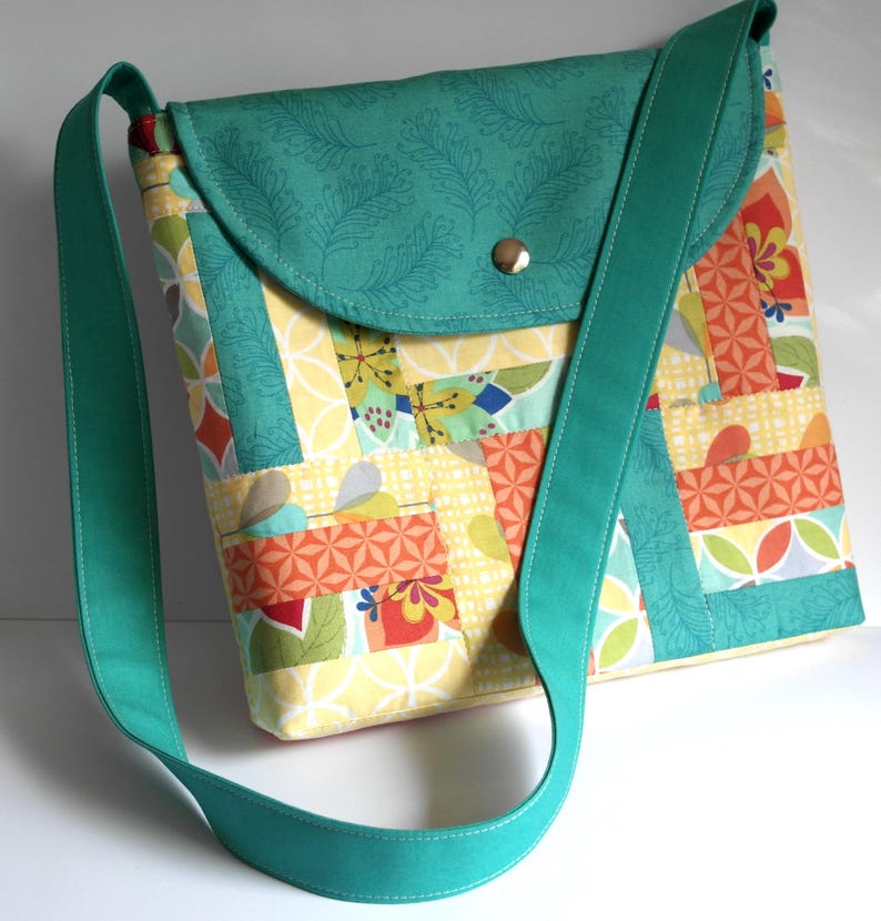 May include: A teal patchwork crossbody bag with a flap closure and a teal strap. The bag is made of various fabrics with geometric patterns in shades of yellow, orange, green, and red.
