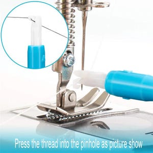 May include: A blue and white plastic sewing machine needle threader tool positioned near a metal presser foot and needle. An inset circular detail shows the thread being guided through the white plastic hook of the threader device.