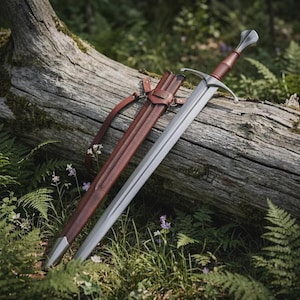 May include: A double-edged steel sword with a brown leather-wrapped grip and a silver crossguard. Beside the sword lies a matching brown leather scabbard featuring a metal tip and an integrated leather strap system for carrying or attachment.