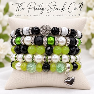 May include: A stack of five beaded bracelets featuring black, white, and lime green beads, accented with silver-tone spacers, rhinestones, and a heart charm. The text "The Pretty Stack Co. MADE TO MIX MADE TO MATCH MADE TO STACK" is visible.