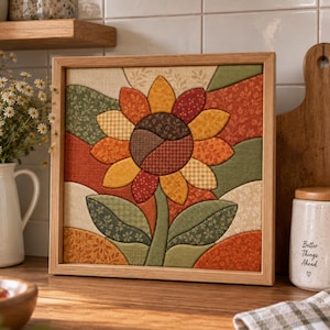 Peut inclure: Une décoration murale en tissu encadrée de forme carrée représentant un tournesol matelassé dans des tons orange, jaune, marron et vert. Le tournesol possède un cœur marron foncé et des pétales superposés sur un fond de panneaux en tissu.