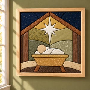 May include: A square framed fabric wall art piece featuring a quilted nativity scene. The design depicts a manger with a swaddled figure under a large white star, set against a dark blue starry sky and patterned green and brown fabric panels.