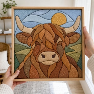 Könnte beinhalten: Ein quadratisches gerahmtes Wandbild mit einer stilisierten Illustration eines Hochlandrindes, das aus verschiedenen braunen, beigen und orangefarbenen gemusterten Stoffsegmenten besteht. Der Hintergrund zeigt einen blauen Himmel mit einer gelben Sonne.