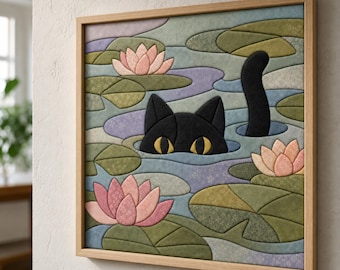 May include: A square framed wall art piece featuring a fabric-textured mosaic of a black cat with yellow eyes peeking out of a pond. The scene includes pink water lilies and green lily pads set against a background of blue and purple water.